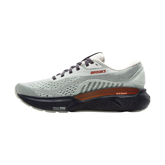 Light gray Brooks running shoe with black midsole, orange side insert, and visible support label