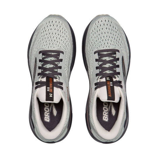 Pair of light gray running shoes with dark laces, black soles, and visible Brooks branding, viewed from above