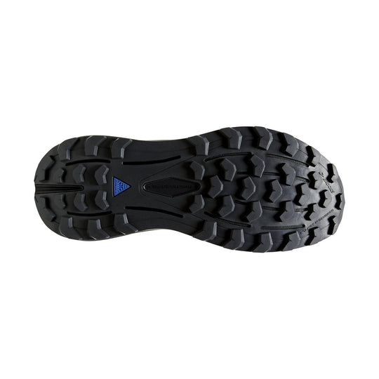 Black trail shoe outsole with deep lugs and a blue triangular logo near the arch