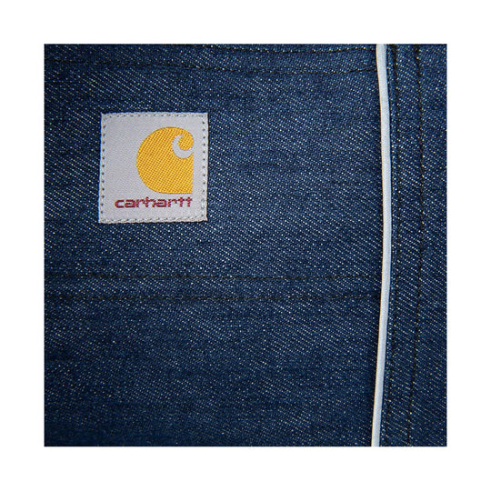 Close-up of blue denim pet coat with Carhartt logo patch and white piping