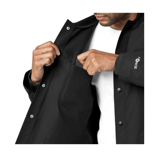 Black scrub coat being opened over a white shirt, with snap front and chest pocket