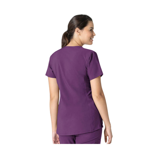 Purple short-sleeve scrub top shown from the back on a model