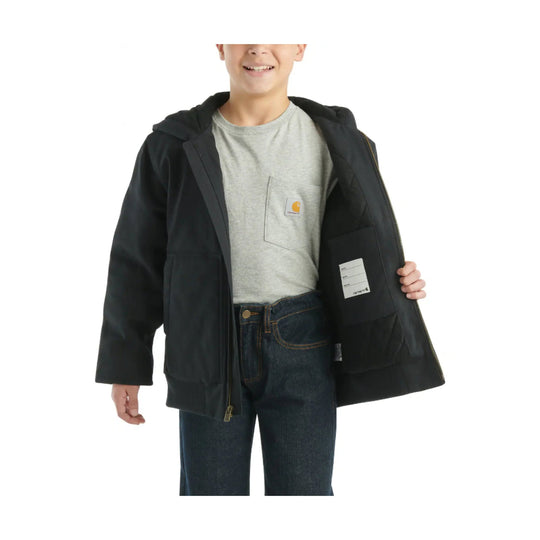 Kid wearing an open black hooded jacket with quilted lining, over a gray T-shirt and jeans