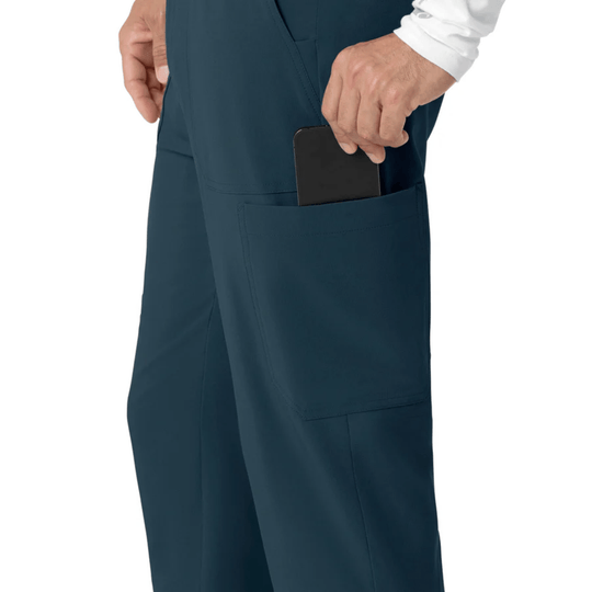 Navy scrub pants with a side cargo pocket holding a phone