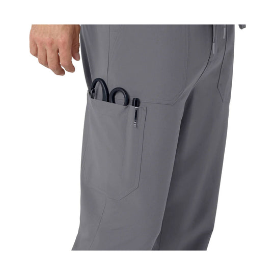 Gray scrub pants with side cargo pocket holding scissors and a pen