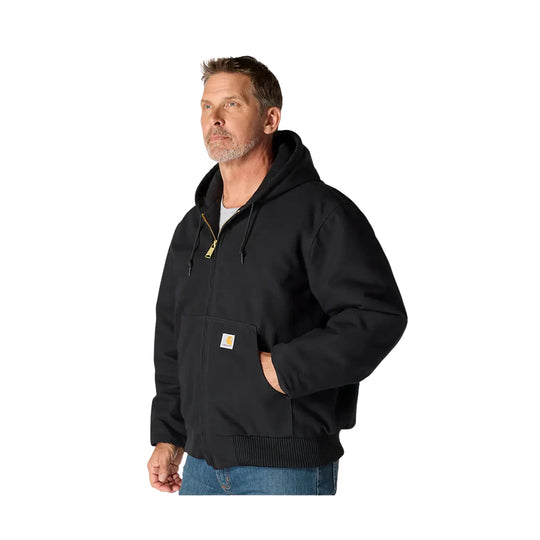 Black hooded work jacket with front zipper, chest patch pocket, and ribbed hem, worn over jeans