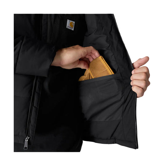 Black insulated jacket opened to show an interior pocket with a hand holding a tan wallet or pouch