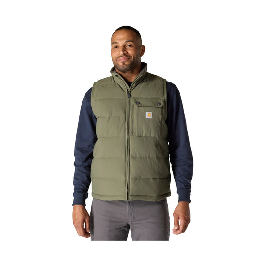 Olive insulated zip-front vest worn over a navy long-sleeve shirt