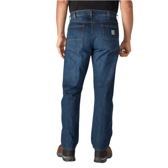 Back view of blue denim work jeans with reinforced back pockets and a small Carhartt patch on the right pocket.