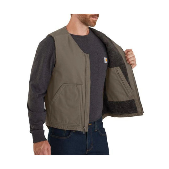 Tan sherpa-lined work vest worn open over a dark long-sleeve shirt