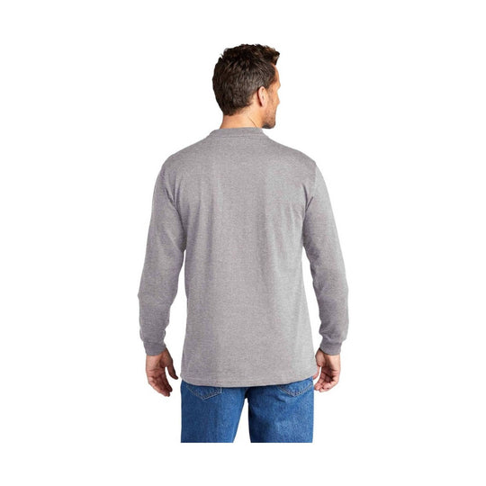 Man wearing a gray long-sleeve shirt and blue jeans on a white background