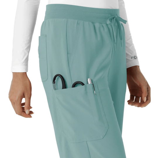 Light blue scrub pants with a wide waistband, drawstring, cargo pocket, and tools in the pocket