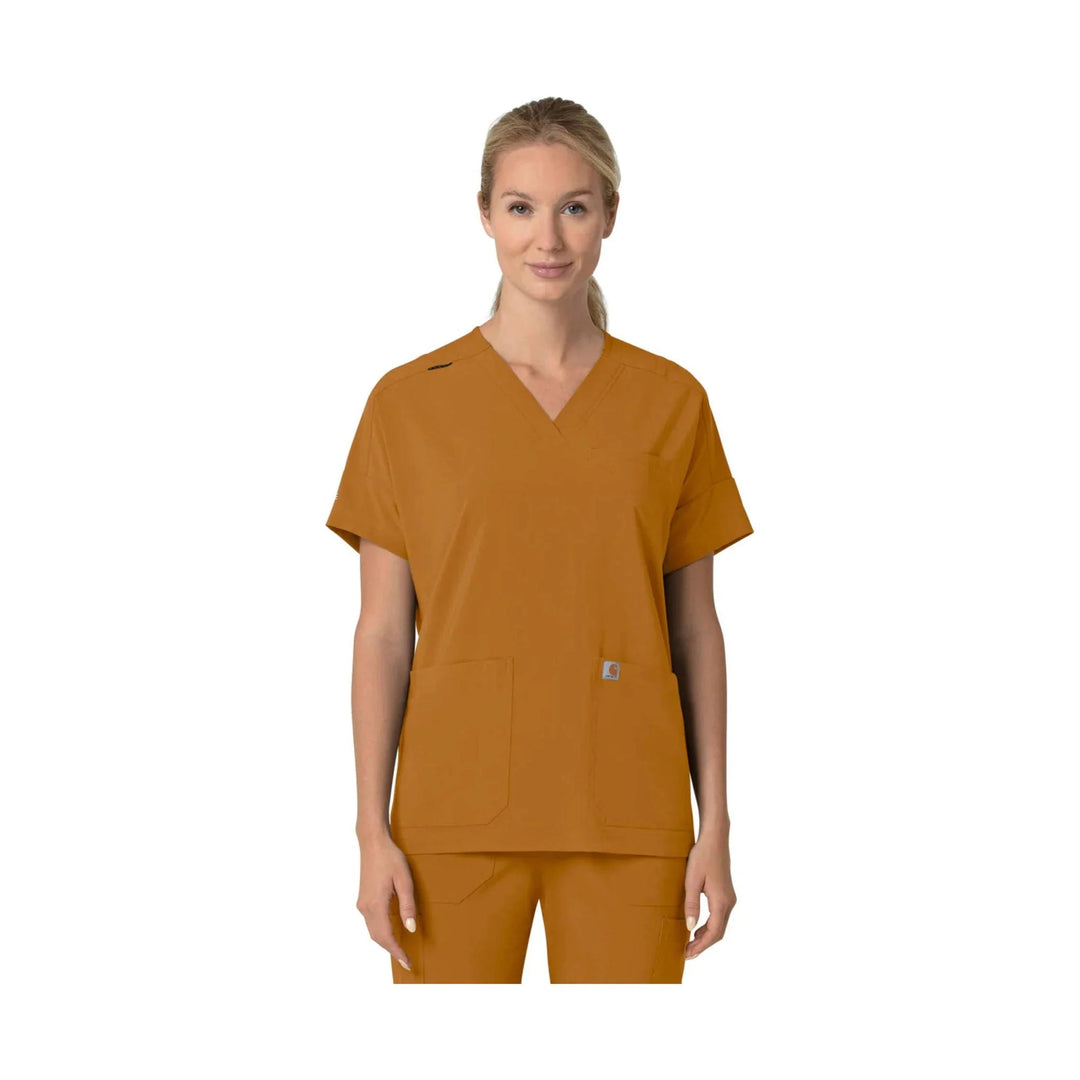 Woman wearing a brown V-neck scrub top with short sleeves and front pockets
