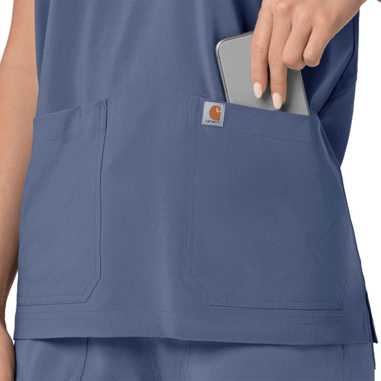 Blue scrub top with large front pockets and a small Carhartt logo label