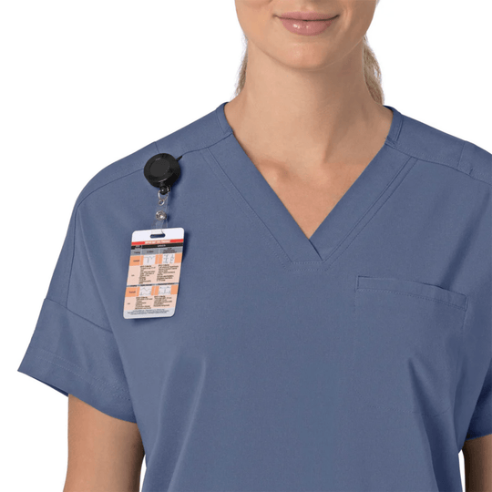 Blue V-neck scrub top with a chest pocket and attached badge reel and ID card