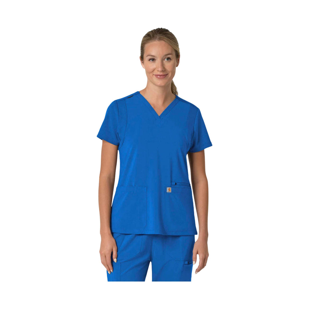 Woman wearing blue V-neck scrub top with short sleeves and front patch pockets