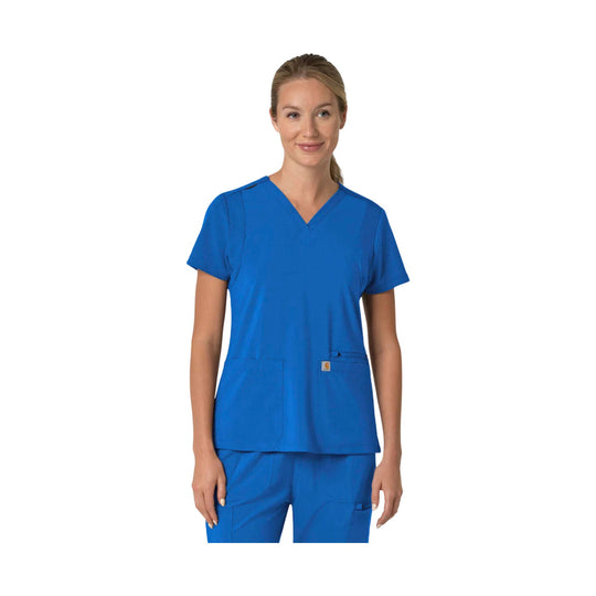 Woman wearing blue V-neck scrub top with short sleeves and front patch pockets
