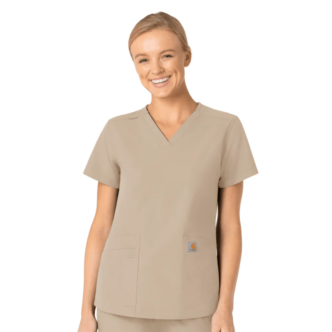 Beige V-neck scrub top with short sleeves, chest pockets, and a small logo patch near the hem