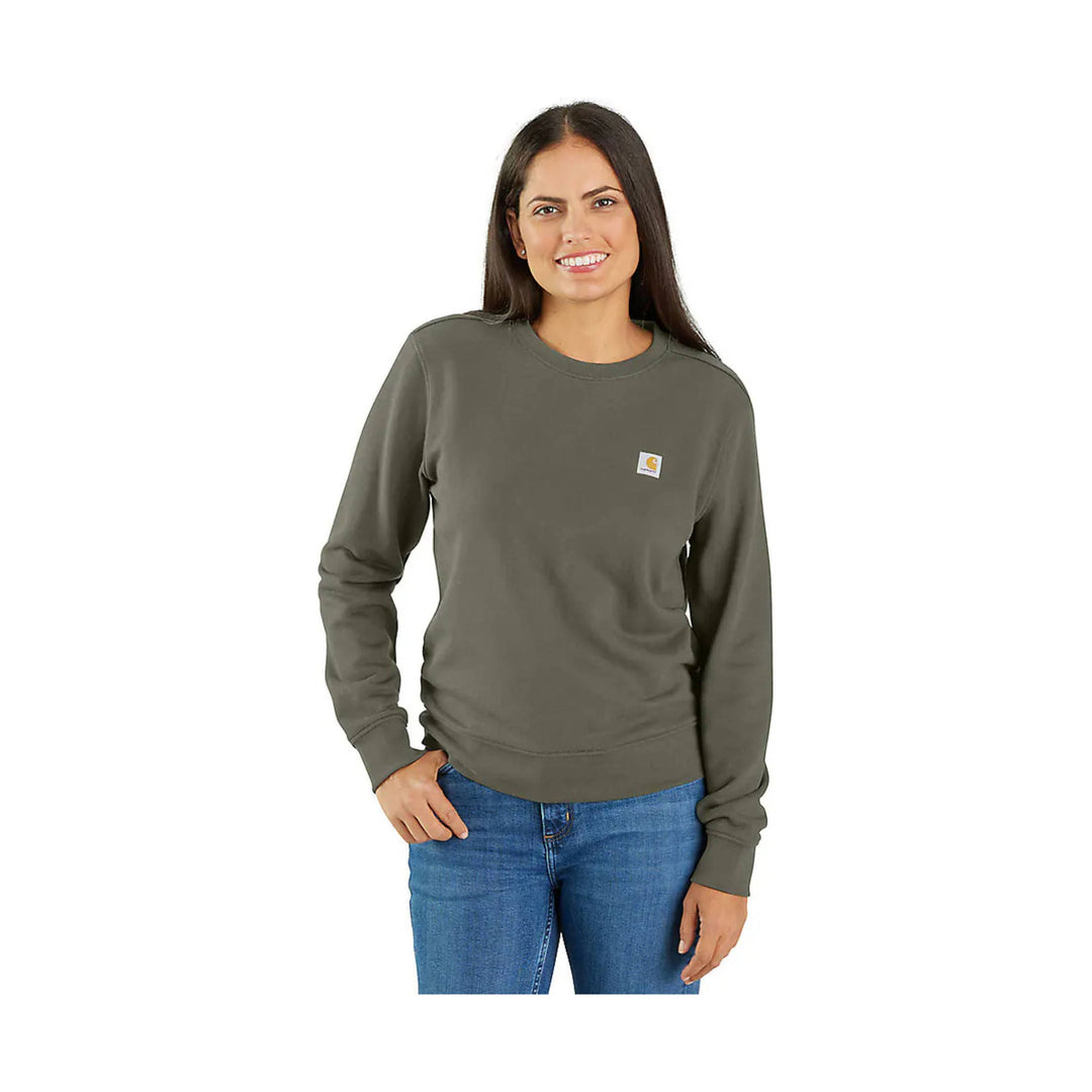 Olive long-sleeve crewneck sweatshirt with a small Carhartt chest patch, worn with jeans