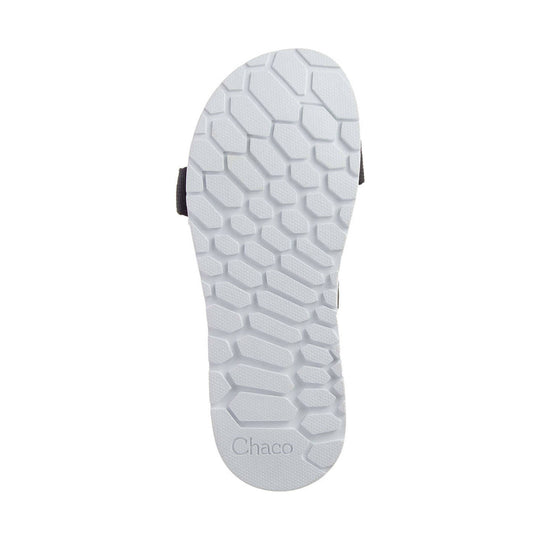 Bottom view of a white rubber sandal sole with hexagonal tread and Chaco branding