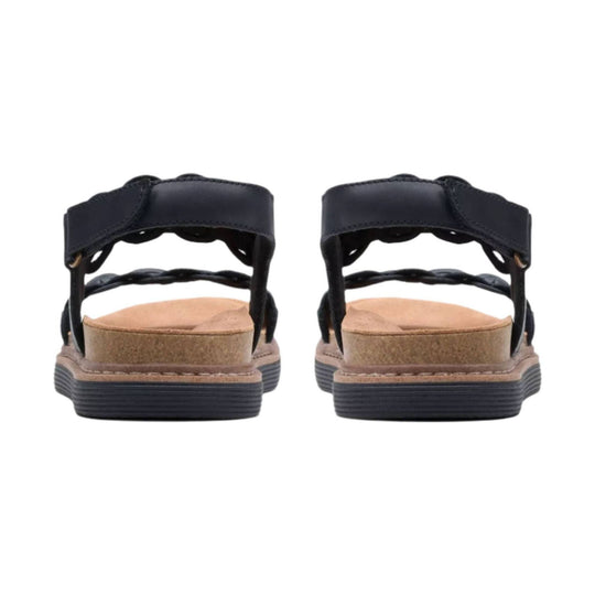Black sandal shown from the back, with a cushioned tan footbed and thick ridged sole