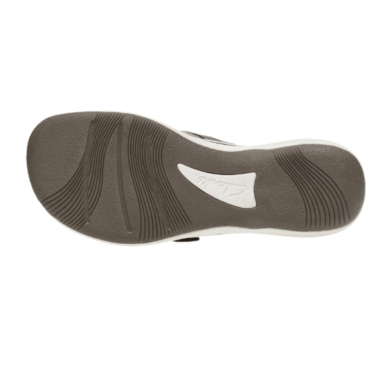 Bottom view of a brown sandal sole with tread grooves and a white Clarks logo cutout