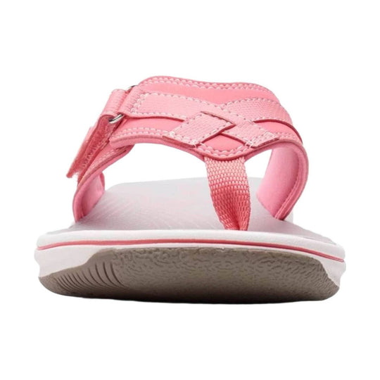 Pink strappy sandal with white sole and textured tread, shown from the front