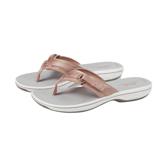Rose gold thong sandals with white cushioned soles and buckle straps