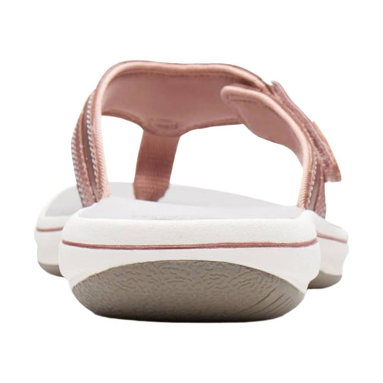 Rose gold slingback sandal with white foam sole and textured beige outsole, rear view
