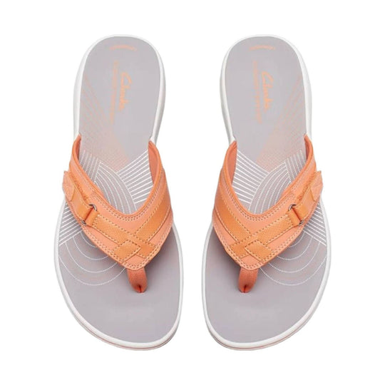 Orange thong sandals with grey footbeds and white stitched detailing, shown side by side from above