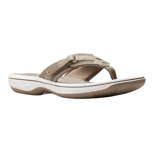 Taupe women’s wedge sandal with crisscross straps, a toe post, and a white cushioned sole