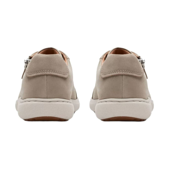 Pair of beige suede loafers shown from the back with white rubber soles