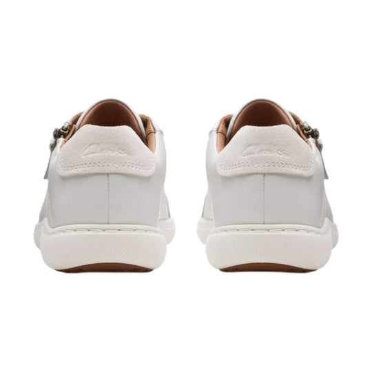 White leather slip-on sneakers shown from the back with tan lining and white rubber soles
