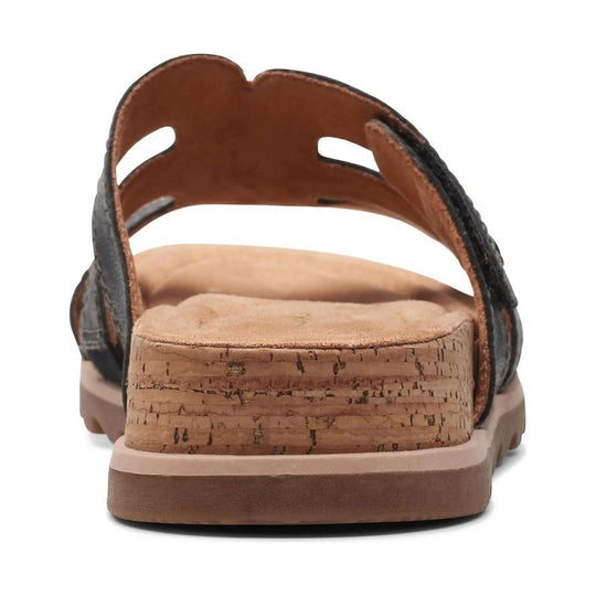 Brown and black sandal with cork wedge heel, open toe, and side cutouts