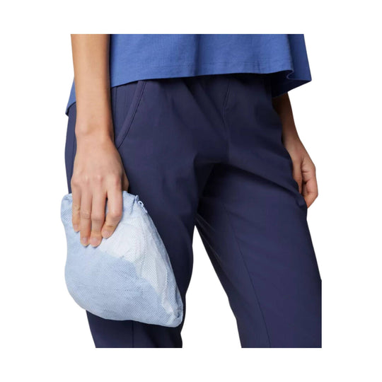 Women's blue athletic pants paired with a matching top, with a light blue drawstring pouch in hand