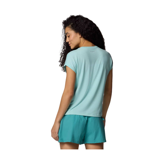 Light blue short-sleeve tee worn with teal shorts, shown from the back