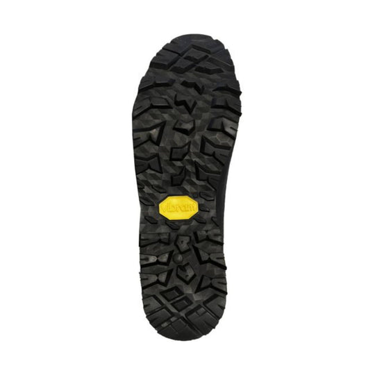 Black rugged boot outsole with deep tread and a yellow Vibram badge