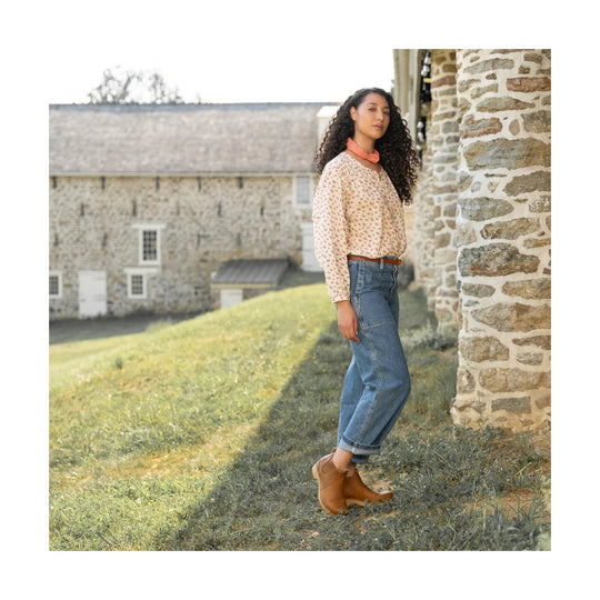 Tan leather ankle boots with side cutout heel and wood heel, shown on a model outdoors