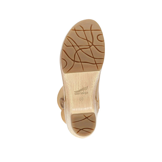 Tan boot sole with tread pattern and a Dansko logo on the heel