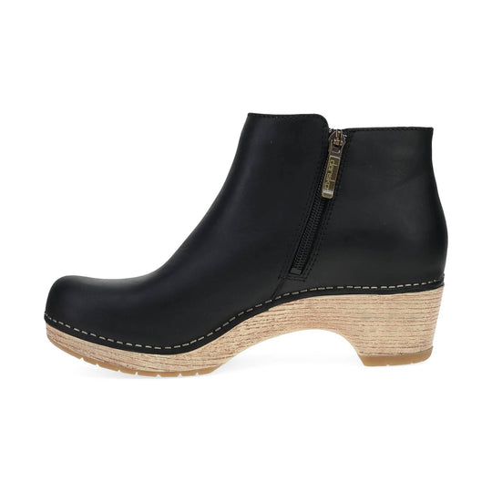Black ankle boot with a side zipper and tan wedge heel