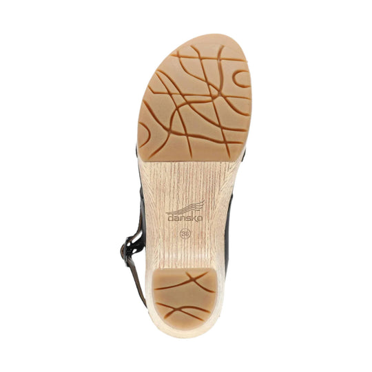 Outsole of a tan sandal with dark tread lines and a wood-look heel, marked “dansko” and size 38