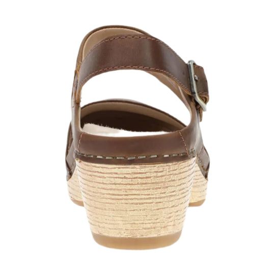 Brown leather sandal viewed from the back with an adjustable ankle strap and stacked wedge heel