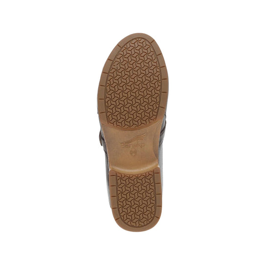 Bottom view of a brown clog sole with textured tread and visible Dansko branding