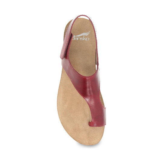 Red leather sandal with an open toe and tan footbed, shown from above