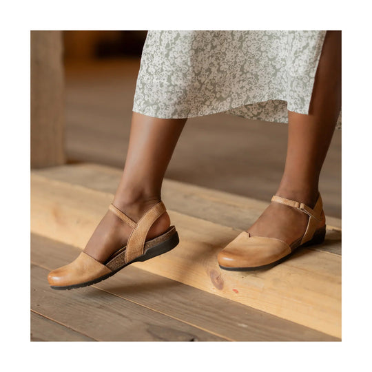 Tan leather closed-toe flats with ankle straps and low heels