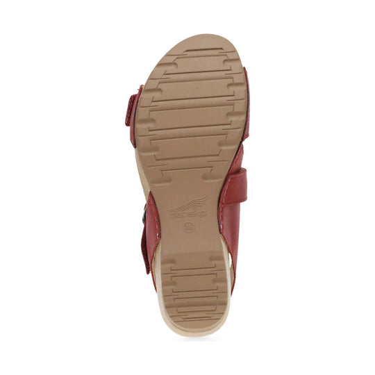 Tan sandal sole with tread pattern and red leather straps visible along the sides