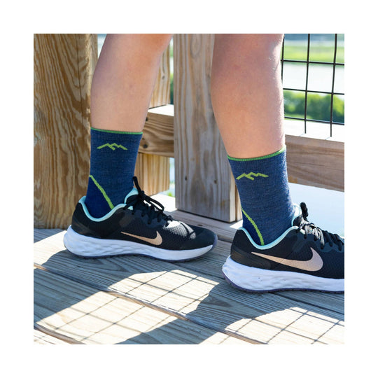 Navy crew hiking socks with neon green accents worn with black running shoes