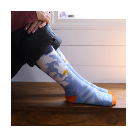 Light blue knee-high kids' ski socks with blue camo pattern and orange toes and heels