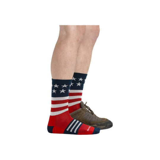 Patriotic red, white, and blue hiking socks with stars and stripes, shown with a brown trail shoe