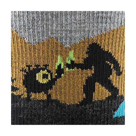 Close-up of a knit hiking sock with gray, tan, black, lime green, and blue geometric pattern